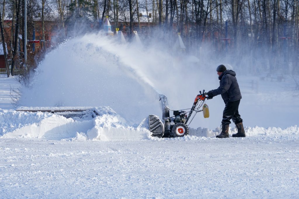 Man blowing snow with a snow blower—how to drain gas from Ariens snow blower?