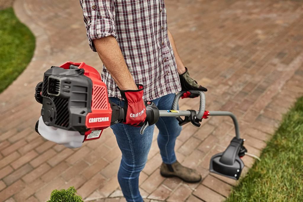 A man edging the lawn with a curved shaft trimmer—how to edge with a curved shaft trimmer?