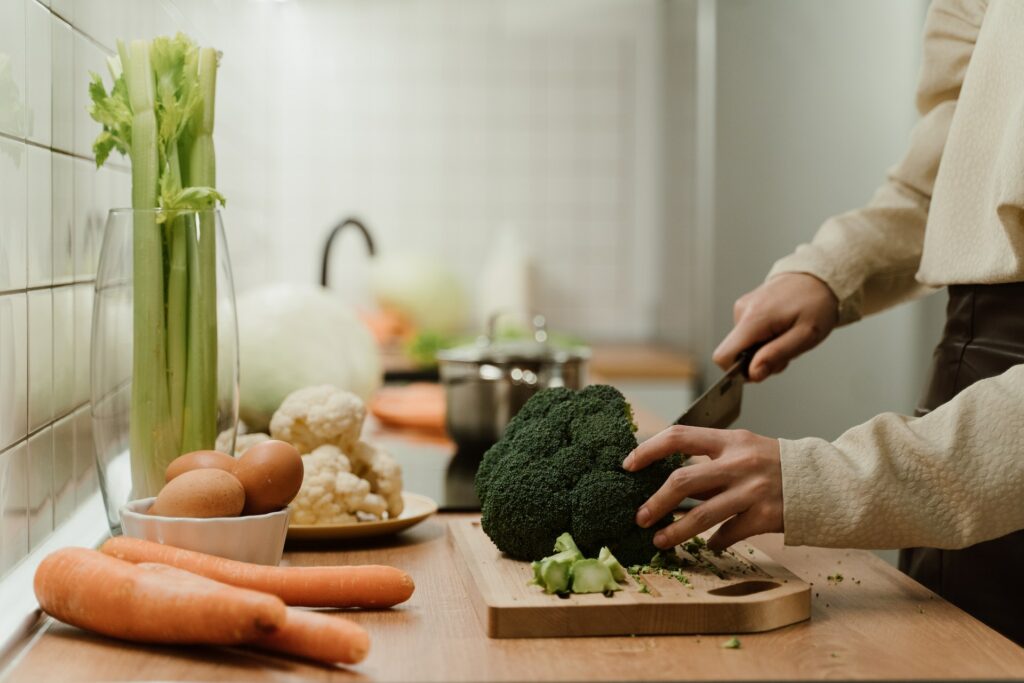 A person cutting vegetables on the wooden cutting board—how to grow broccoli from stem?