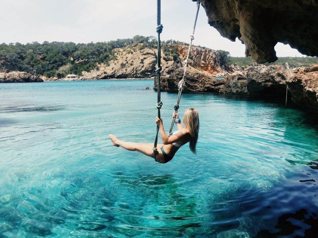 A woman swinging above water—how to hang a rope swing from a tall tree?