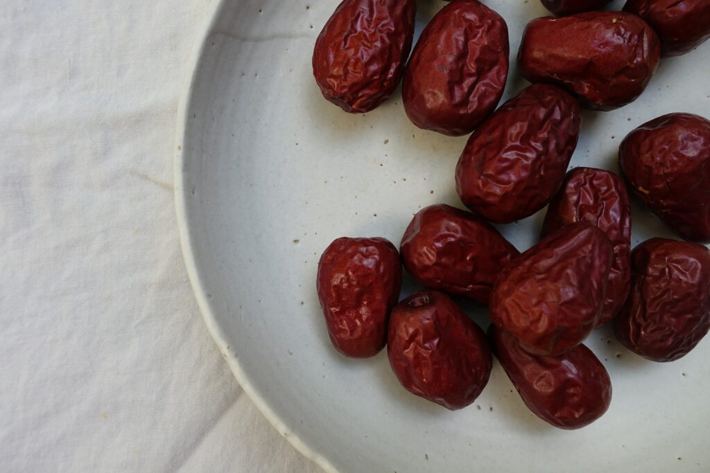 dried red berries on a white plate—how to grow jujube from seed?