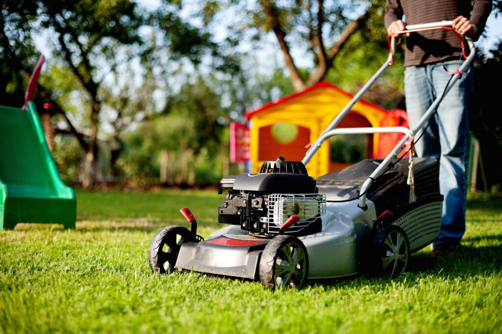 A man with a lawn mower—when can I mow after overseeding?