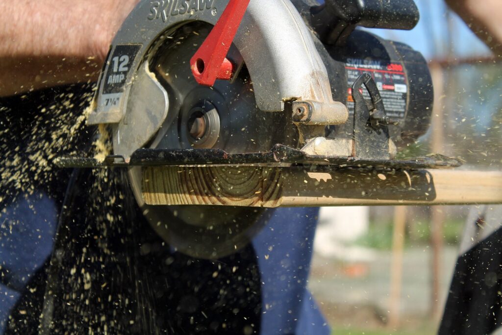 A person using circular saw—corded vs. cordless circular saw.