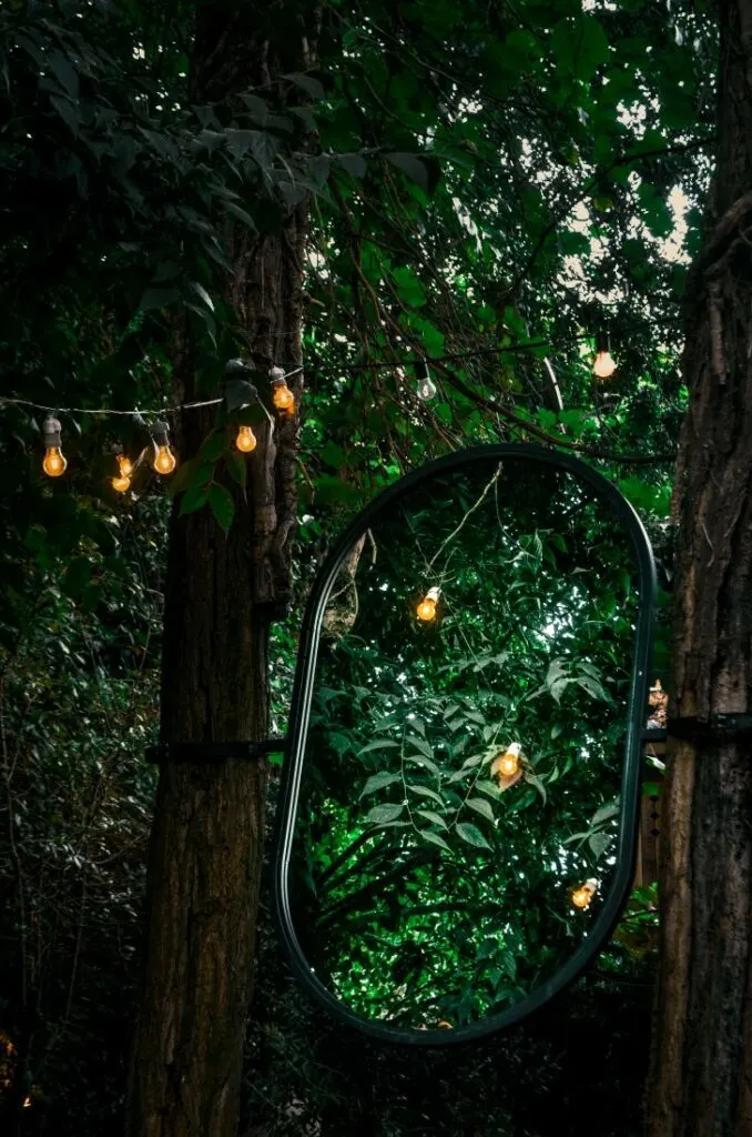 A beautiful mirror reflecting lanterns hanging in a garden